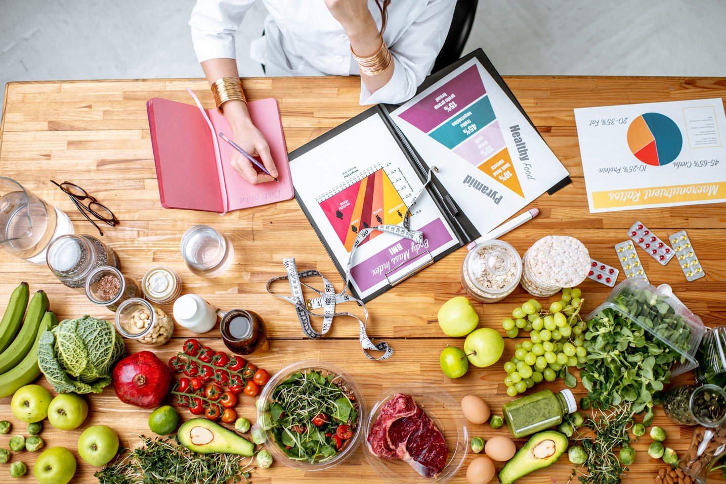 Writing a Diet Plan on the Table Full of Healthy Food